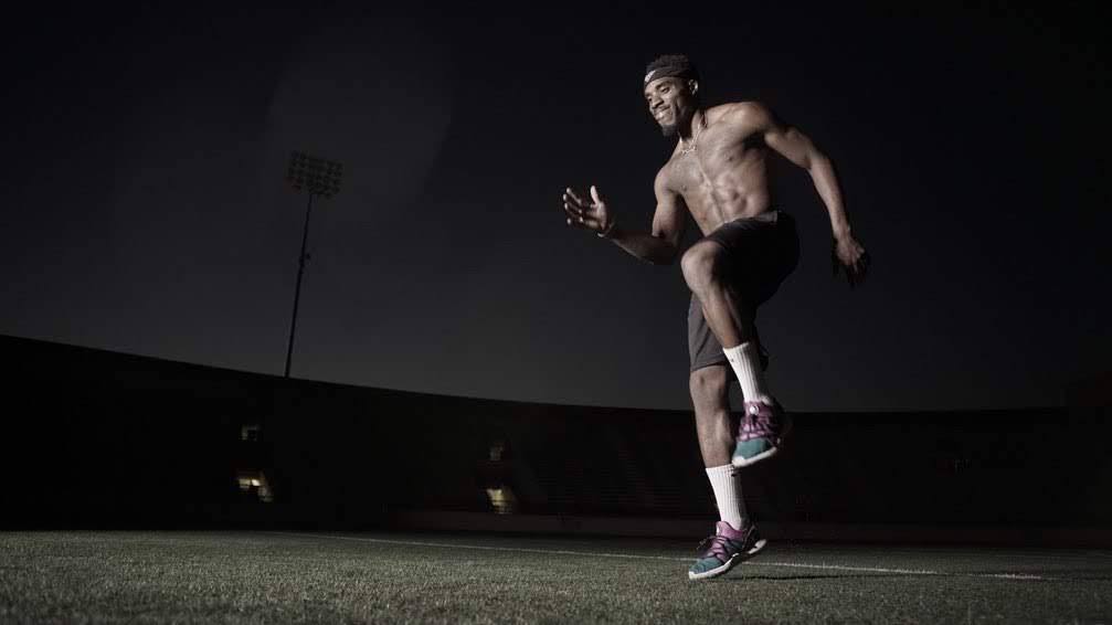 Udoka running high knees in an empty stadium at night